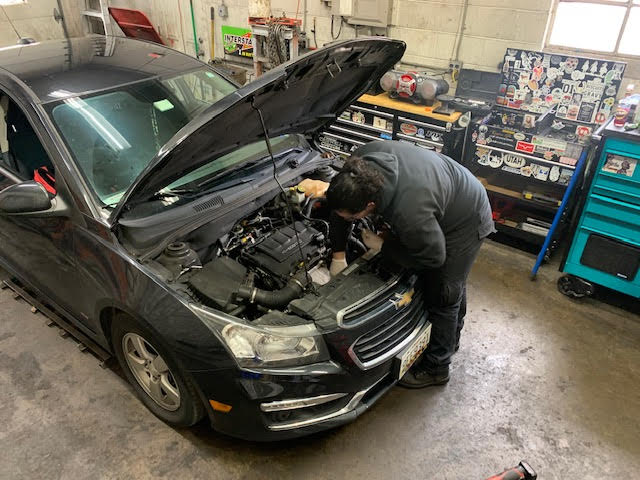 Sebastian Sanchez repairing an automobile